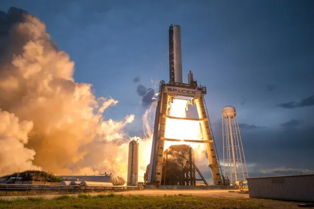 Ilustrasaun kona-ba foguete SpaceX ne'ebé lansa ba espasu, ho gráfiku merkadu finanseiru no símbolu inflasaun iha kotuk, hatu