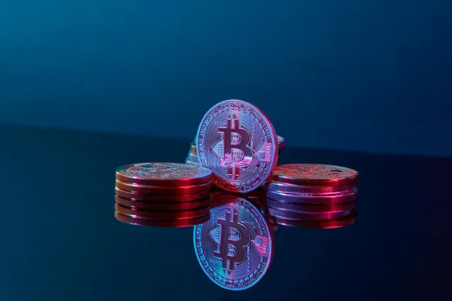 Ema barak tuur iha konferénsia fintech iha Amsterdam, ho tela boot hatudu AI no gráfiku finansiariu, simboliza futuru negósiu