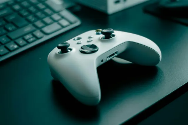 Imajen ne'ebé mostra laptop ho joga video game, no kompania boot sira iha mundu jogu, hanesan balatro no fandon.