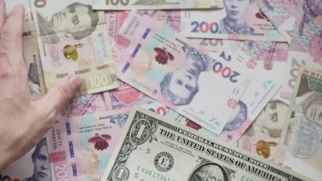 Gráfiku hatudu monu dólar no prezu minarák iha loron akordo paz entre Estados Unidos no Irán, ho bandeira rua no seta ba krai