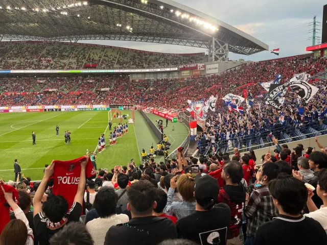 Fã sira husi Japaun ho uniforme azul no kapela mak ponta estadiu depois jogu World Cup, hatudu respeitu no unidade liu husi a