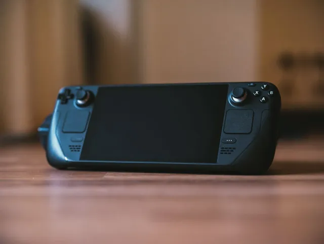 Imajen hatudu adaptador Bluetooth Twelve South AirFly Pro 2 iha meja, ho earbuds wireless no aviaun iha fundu, simboliza entr