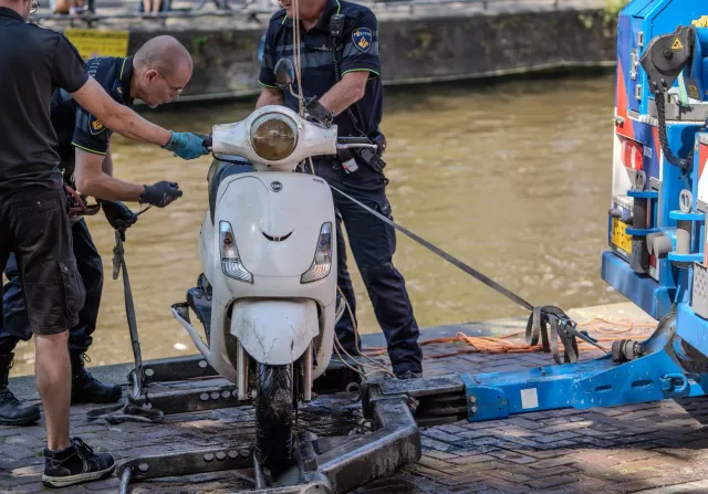 Siklista ida ho kapas iha estrada sidade, ho karreta no scooter elétriku iha foku liur, ilustra kona-ba seguransa no perigu v