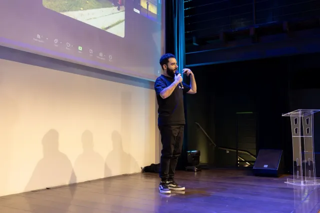 Imajen husi palco Microsoft Build 2026 iha San Francisco, ho apresentadór sira no ekrã boot hatudu AI teknolojia, no audiénsi
