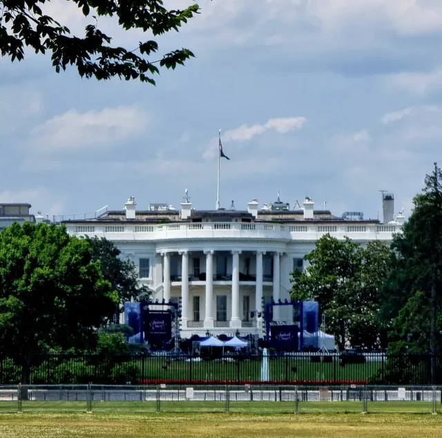 Imajen ida ne'ebé hatudu eventu UFC iha White House nia South Lawn, ho ema barak tuur hela, no Presidente Donald Trump iha so