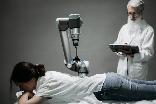 Robot cirurjia ne'ebé uza intelijênsia artifisiál iha sala operasaun atu trata moras spine, ho doutór sira monitoriza proses