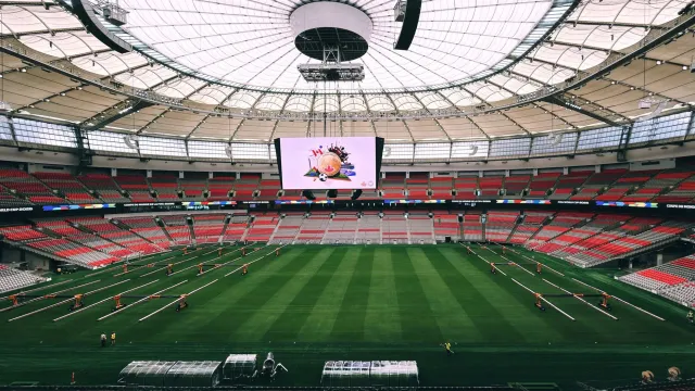 Fotografia husi jogu fuból Mundial 2026 entre Qatar no Canada iha estadiu, ho jogadór sira prepara atu komesa partida