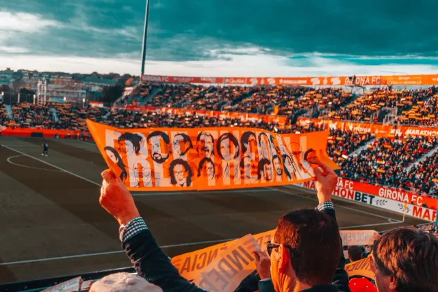Ema barak iha estádio fuból lori tiha bandeira protestu, hatudu tensaun entre fã sira no politika iha mundiál 2026