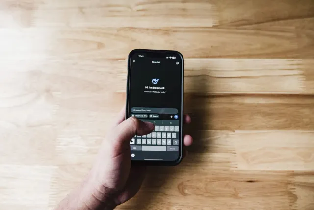 Ema ida uza smartphone ho aplikasaun AI hanesan ChatGPT hodi deside sasan atu sosa iha loja online