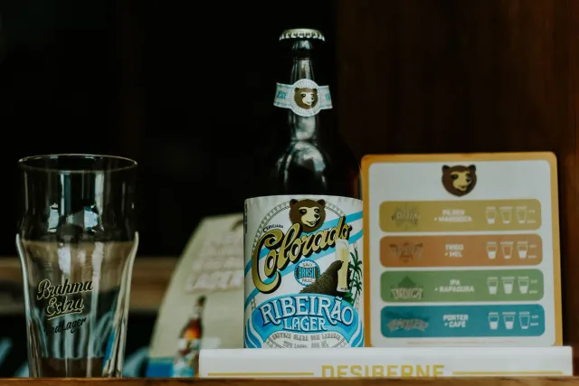 Imajen hatudu kampanha futebol iha Coloradu, ho ema barak joga futebol no hemu cerveja