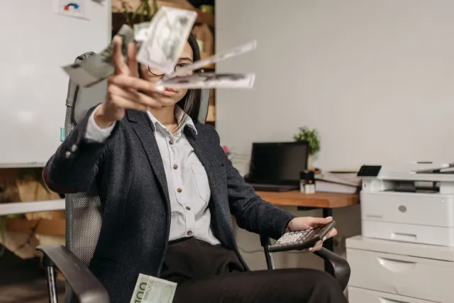 Imajen ida hatudu ema joven ho laptop, simboliza rikeza husi teknolojia espasu no planeamentu finansa pessoal iha Timor-Leste