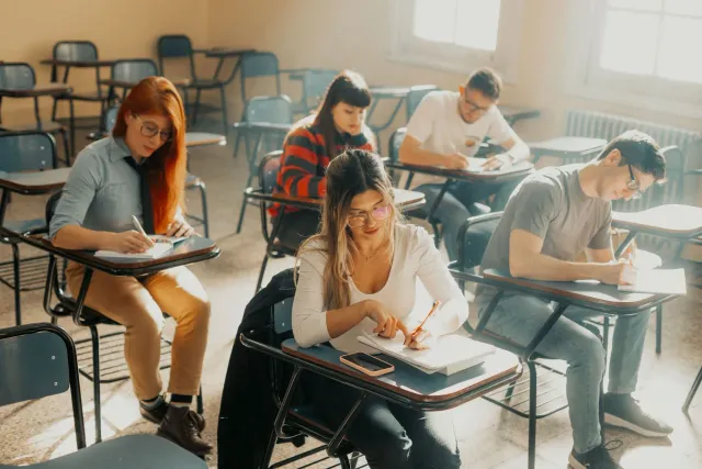 Estudante sira protesta iha liur husi edifísiu, ho plaka ne'ebé hakerek 'NEET exam fair', no aviaun IAF iha lalehan
