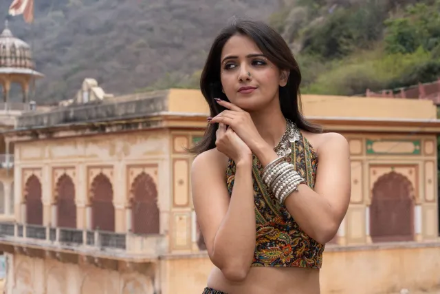 Aktris Rakul Preet Singh ho sorriso, iha laran liur, ho planu fundu ne'ebé hatudu teknolojia foun hanesan TV haier no bowling
