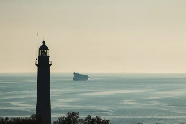 Imajen hatudu ema indianu sira hanesan seafarer iha barka iha tasi, ho bandeira Indonézia no EUA iha kotuk, simboliza negosia