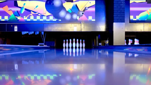 Imajen hatudu lane oil bowling ho padraun mina ne'ebé aplikadu ho máquina, ho bola bowling iha superfísie lane, ilustra oinsá