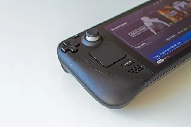 Imajen husi Steam Controller Valve nian, kontroladór jogu kór preto ho kilik botão, iha fundu ne'ebé la klaru