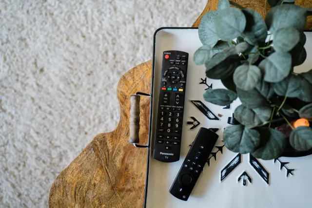 Imajen ida hatudu dispositivu Roku iha sala família, ho televizaun no kontrolu remoto. Dezenu simples no modernu, hatudu oins