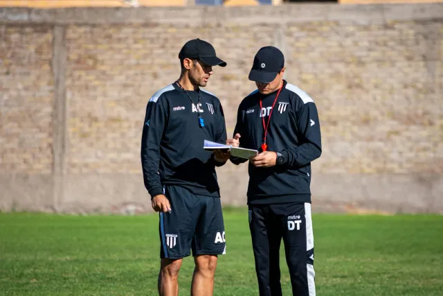 Treinador futebol ida hatudu estratégia ba jogador sira iha kampu, ho bola no tátika desenha iha quadru