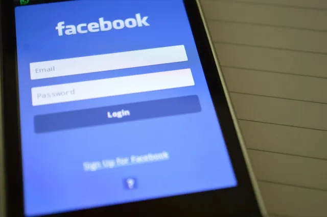 Ema ida kaer smartphone ho Facebook aplikasaun ne'ebé hatudu konfigurasaun privasidade no AI Mode, iha laran iha imajen atlet