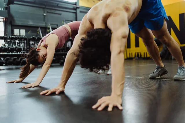 Imajen hosi partisipante sira iha campu yoga no treinamentu desportu, hatudu sira halao atividade yoga iha kampu futebol