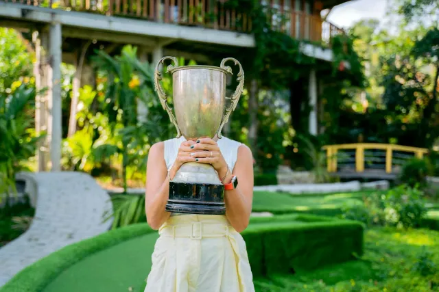 Ekipa golf universitária selebra tiha kampiaun iha torneiu NCAA, ho troféu iha liman no sorrisu boot