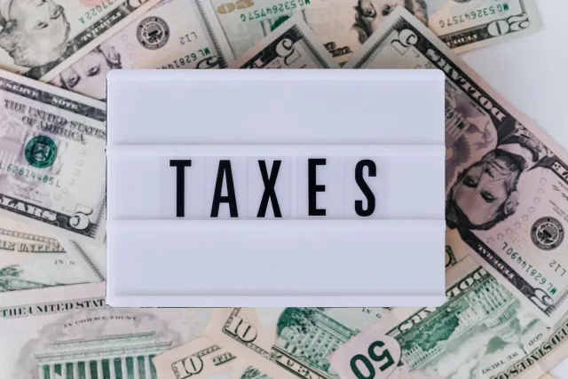 Rei Charles husi Reinu Unido tuur iha meja ho dokumentu finanseiru, hatudu oinsá sira publika taxa pessoal ba primeira vez ih