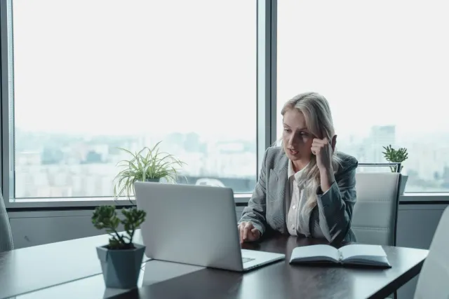 Imajen ema negósiu iha escritório, hanesan lideransa ne'ebé prepara an ho laptop, representa mudansa iha mundu negósiu global
