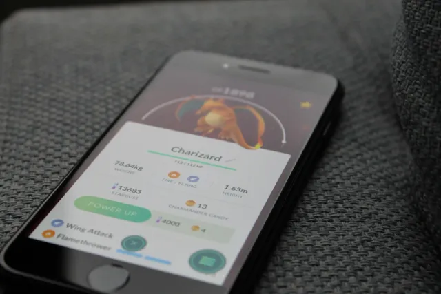 Imajen hatudu jogador joga Pokémon Champions iha smartphone ka komputador, ho pokémon sira iha tela, iha estilu modernu no at