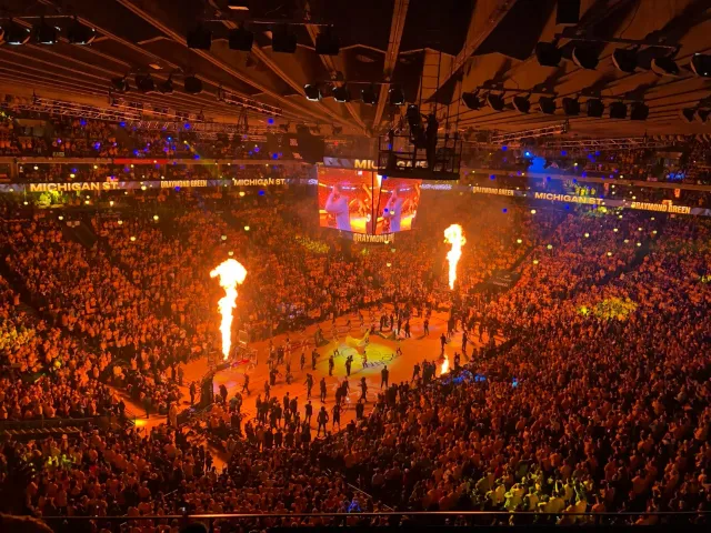 Fã NBA sira iha estádiu hodi sorak no hatudu enerjia boot durante jogu. Sira uza kamisa Knicks no hatudu entuziasmu.