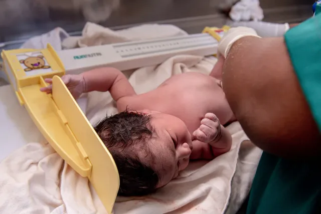 Imajen ida hatudu inan no labarik iha ospital iha India, ho enfermeira ida tau matan ba sira, hanesan símbolu ba melloramentu