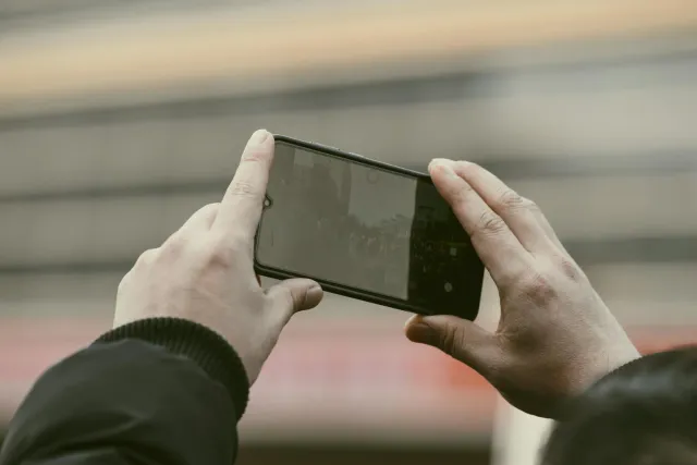 Ema ida uza smartphone atu grava situasaun iha liur, hanesan ezemplu oinsá teknolojia ajuda ita koleta evidénsia ba seguru