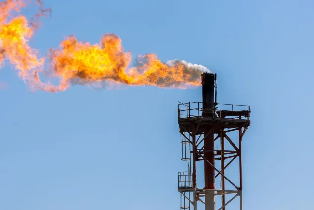 Imajen hatudu xaminé gas flaring ne'ebé sunu hela iha rai maran, ho ahi boot no fumaça sa'e ba lalehan, no iha okos, ema sira