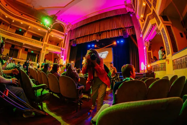 Imajen kona-ba eventu PlayStation State of Play ne'ebé hatudu auditoriu no tela boot ho logo PlayStation, iha ambiente entusi