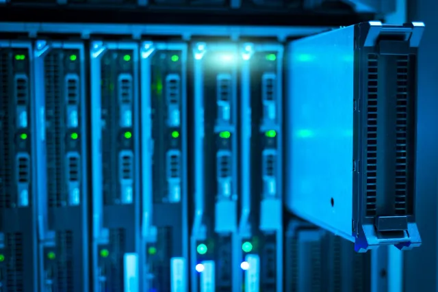 Imajen ida ne'ebé hatudu salaun servidor ho luz azul no komputador sira, ne'ebé representa teknolojia AI no Infosys nia futur