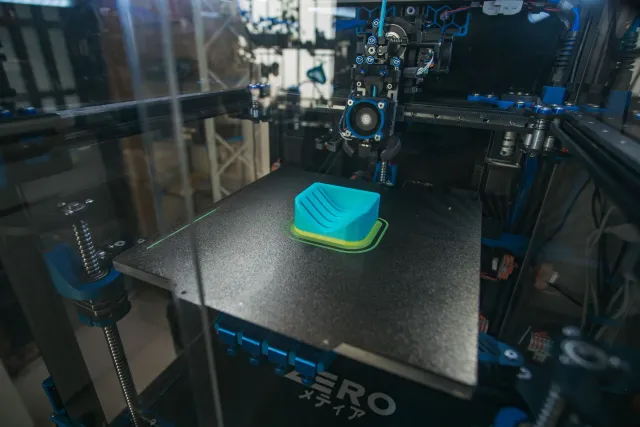 Imajen hatudu bateria ne'ebé kria ho teknolojia 3D printing, ho forma livre no ki'ik, iha laran husi aparellu eletróniku hane