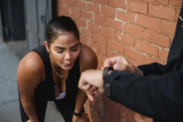 Atleta ida uza fitness tracker iha liman durante treinu, ho smartwatch iha liman seluk, no televizaun hatudu analiza jogu iha