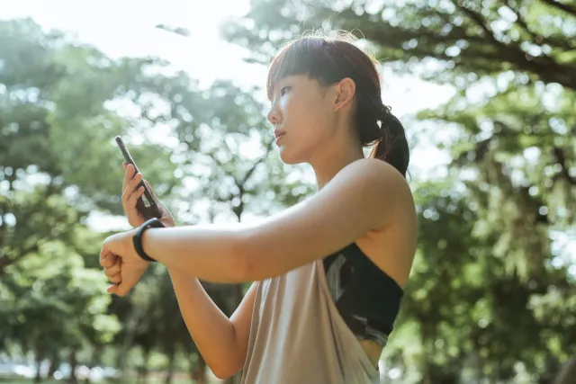 Atleta ida uza fitness tracker iha nia liman durante treinu iha kampu, hatudu oinsá teknolojia ajuda monitoriza isin nia ativ