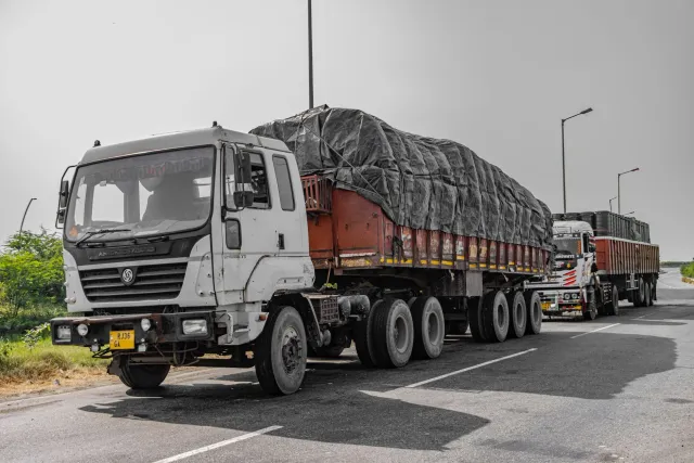 Imajen kareta kontentor ne'ebé ahi boot iha dalan Mumbai-Ahmedabad, ho fumaça boot no bombeiru sira servisu, iha Palghar, Índ