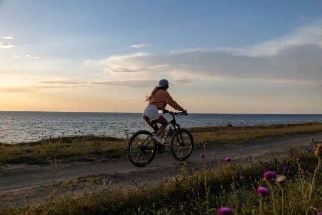 Ema ida halo biking iha dalan iha natureza, ho sorrisu iha rosto, hatudu oinsá exercísiu simples bele hadi'a humor no saúde m