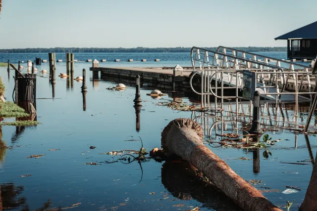 Imajen hatudu kampu férias Camp Mystic iha Texas depois inundasaun boot, ho tenda no edifísiu estragadu, no ema servisu atu h