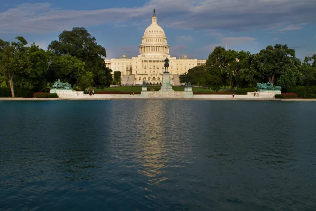 Imajen reflecting pool iha Washington D.C. ho edifísiu Kapitólio iha kotuk, hatudu renovasaun ne'ebé kontroversa