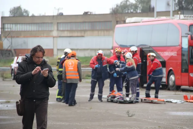Imajen hodi hatudu minibus ne'ebé monu ba iha kraik estrada, ho ema servisu resgate no ambulánsia iha fatin – ilustra risku m