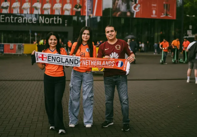Imajen hatudu jogador futebal husi Tunisia no Netherlands iha partida FIFA World Cup, ho torcedor sira iha estadiu