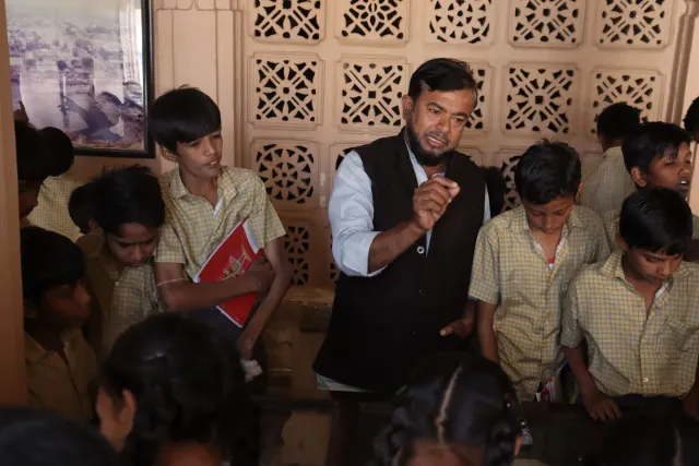 Imajen ida ne'ebé hatudu klase iha eskola remotu iha Maharashtra, Índia, ho profeitór sira hanorin estudantes uitoan iha sala