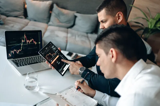 Líder negósiu sira analiza dadus investimentu AI iha futuru, ho gráfiku no komputadór iha meja