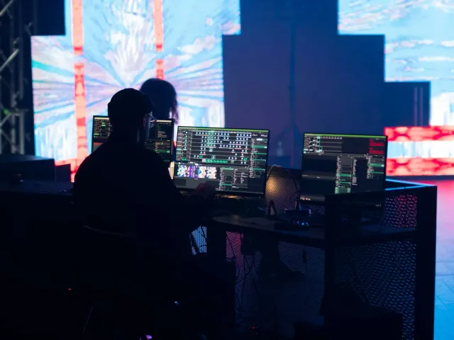 Imajen ida hatudu palco eventu teknolojia ho tela boot ne'ebé hatudu logotipu Summer Game Fest, WWDC no Android 17, ho ema ba