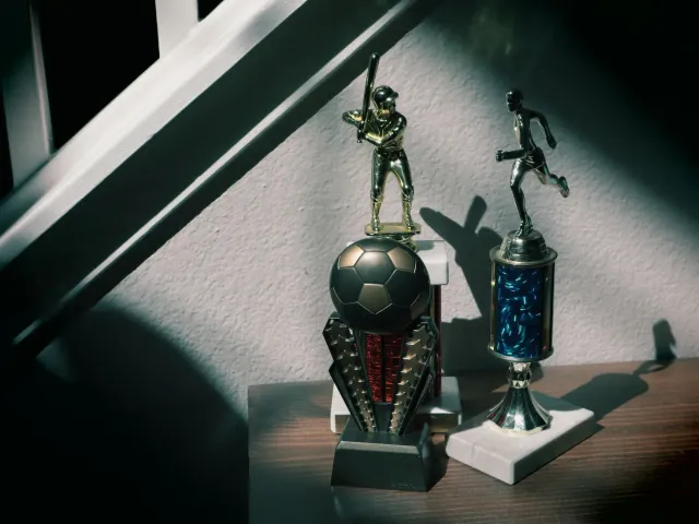 Foto atletu desportu ne'ebé manan troféu iha salaan memoria, hatudu oinsá desportu la osan de'it maibe historia.