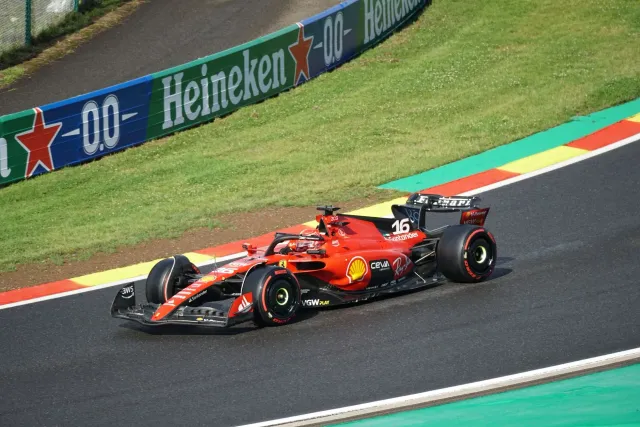 Imajen husi karru Ferrari F1 ne'ebé kompete iha ladeira, hatudu velosidade no risku ne'ebé atleta sira enfrenta.