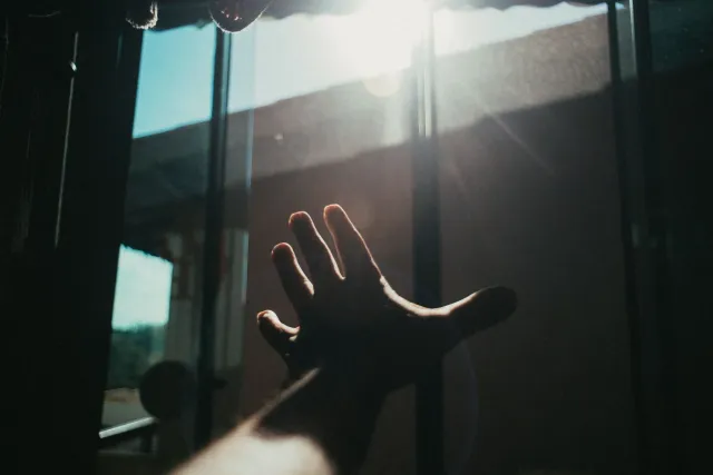 Ema ida tuur iha janela nia sorin, simu luz dadeer naroman, ho matan loke no isin relaxa, hatudu oinsá luz dadeer bele ajuda 