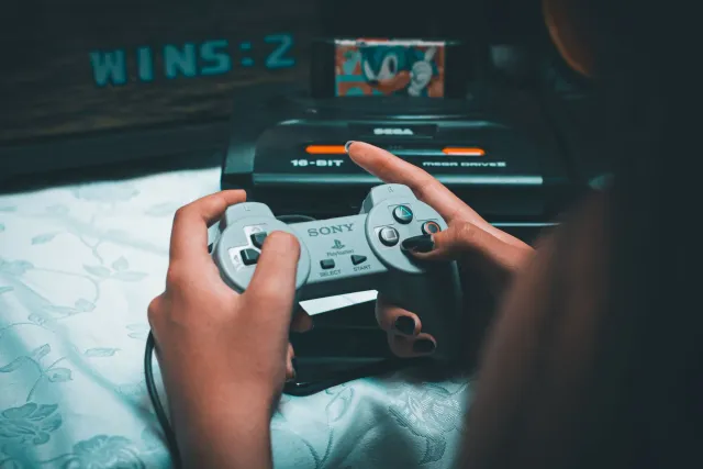 Imajen ida hatudu konsola Nintendo Entertainment System ho kable modernu no simbolu Apple TV no Disney iha fundu, ilustra fut